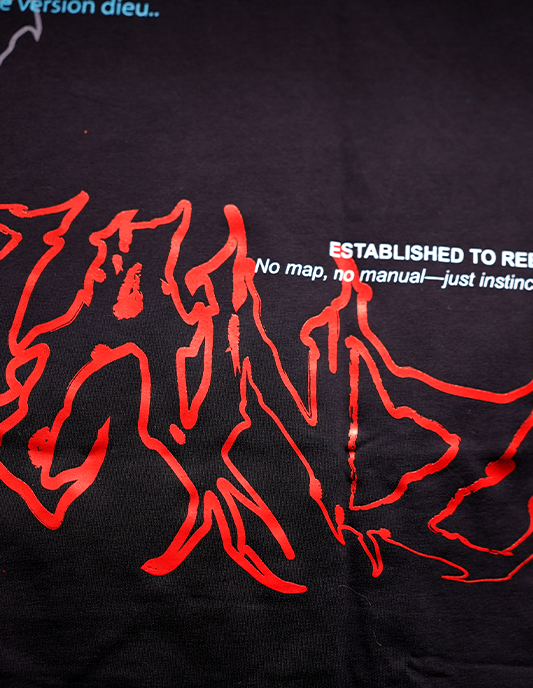 Black shirt with red abstract designs and white text on a dark background