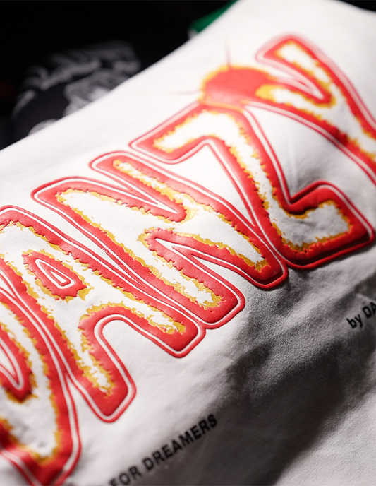 Close-up of a white pillow with red and yellow text on a black background