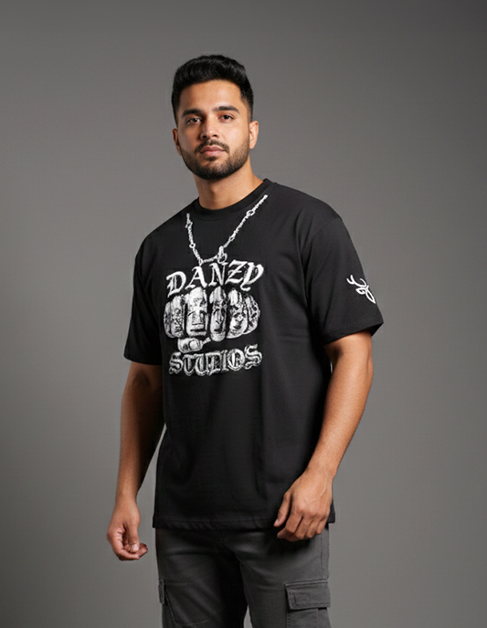 Man wearing a black t-shirt with white text and graphics on a gray background